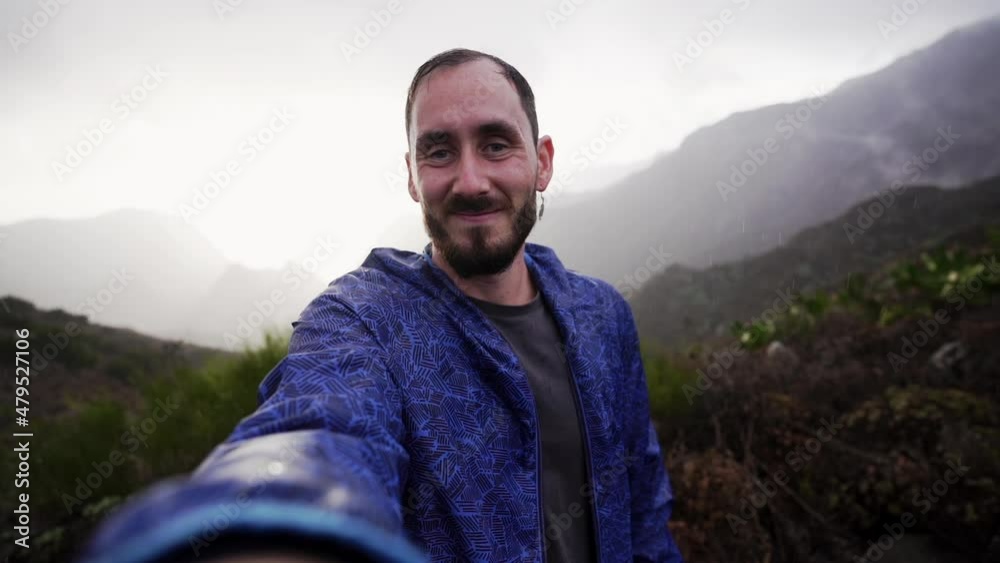 Happy Caucasian smiling at camera while it rains on island of Tenerife. Circling Happy Caucasian smiling at camera while it rains on island of Tenerife. Circling