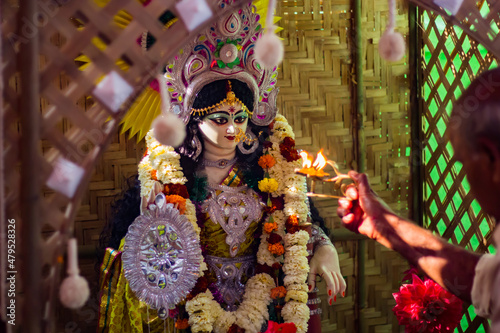 saraswati puja festival rituals being performed by priest. idol of hindu goddess saraswati in background. photo