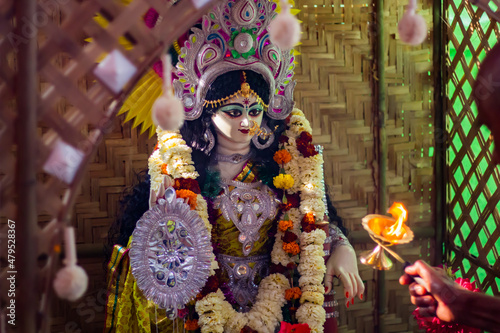 saraswati puja festival rituals being performed by priest. idol of hindu goddess saraswati in background. photo