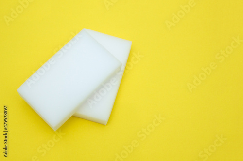 Melamine sponge for cleaning on a yellow background. The concept of cleanliness and detergents