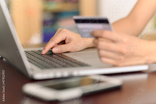Close up woman hands holding credit card and using laptop shopping purchasing online. e-commerce, internet banking, checking balance, banking service, paying by credit card, making payment.