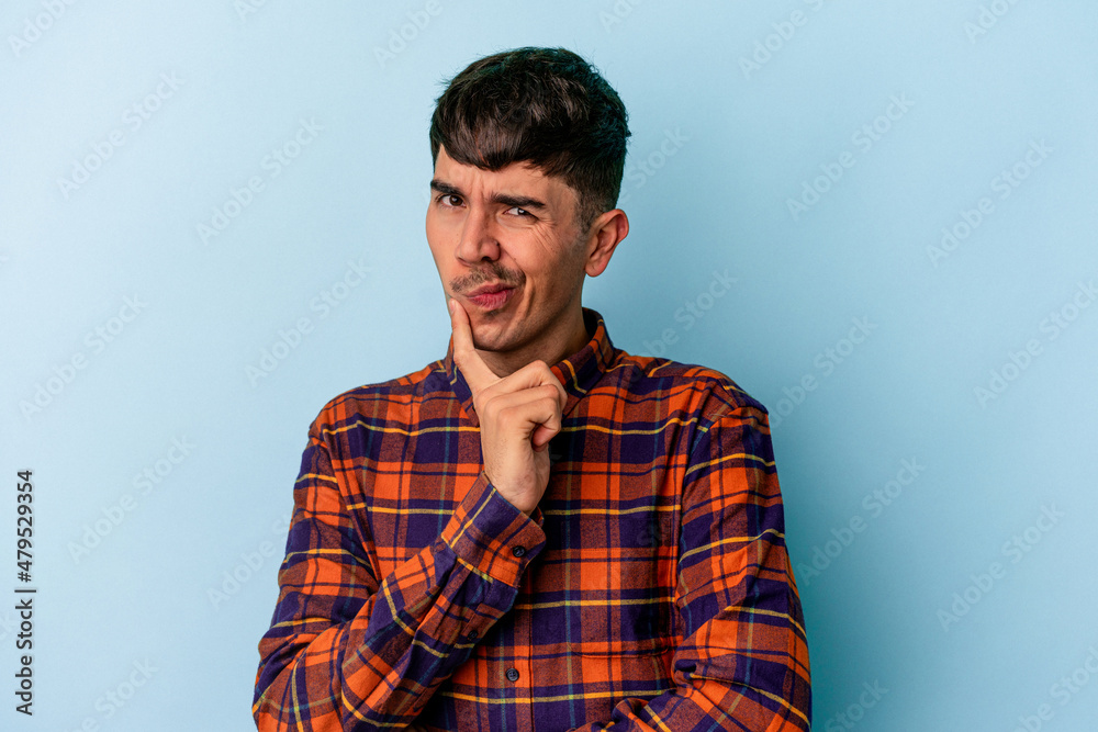 Young mixed race man isolated on blue background contemplating, planning a strategy, thinking about the way of a business. Young mixed race man isolated on blue background contemplating, planning a strategy, thinking about the way of a business.