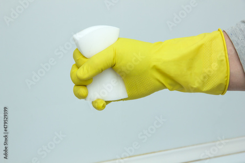 A gloved hand squeezes a melamine sponge. The concept of home cleanliness and cleaning. photo