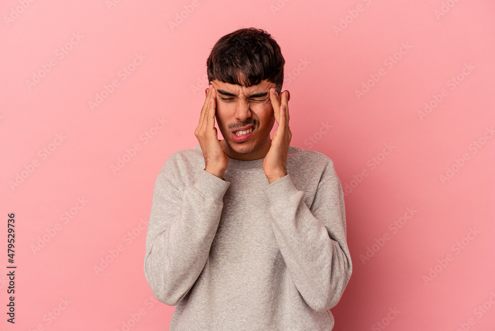 Young mixed race man isolated on pink background having a head ache, touching front of the face.
