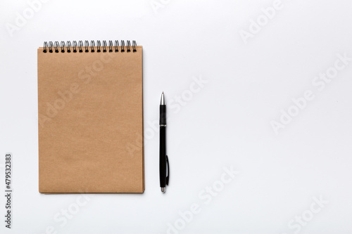 school brown notebook on a colored background, spiral craft notepad on a table Top view