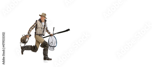 Flyer with young man, professional fisherman with fishing rod, spinning and equipment going to river isolated over white studio background