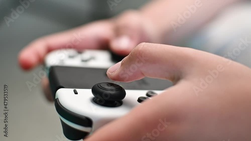 Boy playing video game using joystick, close up photo