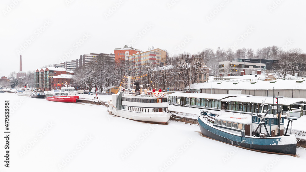 Small boat are moored at river coast in winter