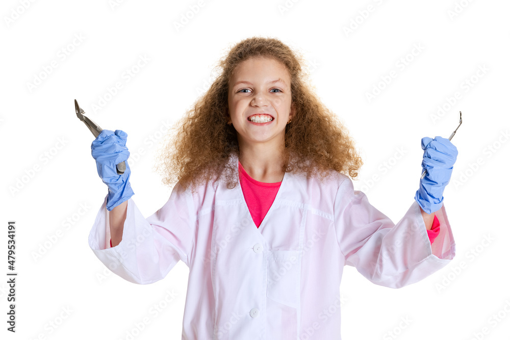 Half-length portrait of cute beautiful little girl, child in image of dentist doctor wearing white lab coat and gloves isolated on white studio background Half-length portrait of cute beautiful little girl, child in image of dentist doctor wearing white lab coat and gloves isolated on white studio background