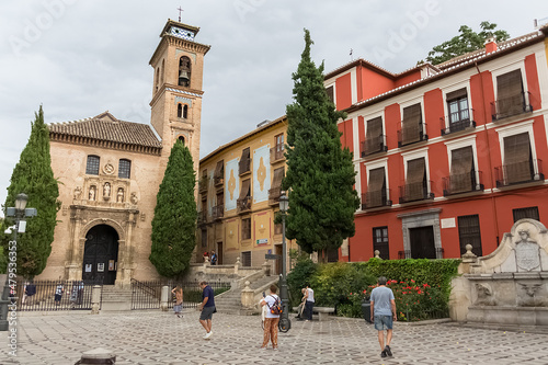 View at the St. Ana square with San Gil and Santa Ana Church, heritage colored buildings and Carrera del Darro to the street sad walk in Granada, Spain photo