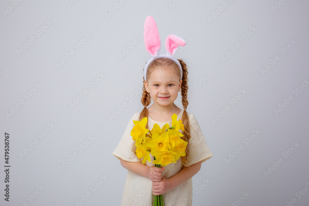 cute little girl with bunny ears holds a bouquet of yellow daffodil flowers on a white background, cute little girl with bunny ears holds a bouquet of yellow daffodil flowers on a white background,