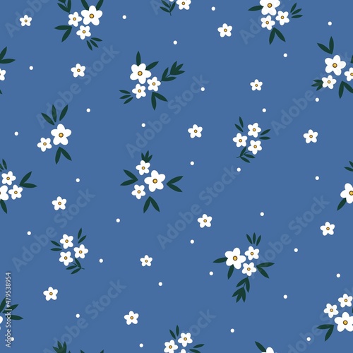 Beautiful vintage pattern. Small white flowers and dots, dark leaves. Blue background. Floral seamless background. An elegant template for fashionable prints.