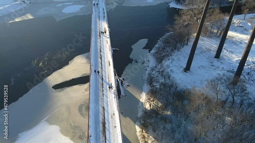 Aerial view of people at stone arch bridge crossing the mississippi river in Minneapolis winter afternoon ice formations photo