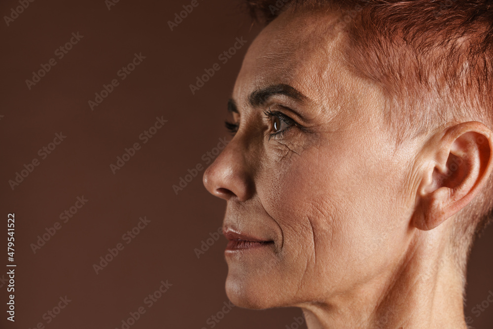 Fototapeta premium Senior ginger woman with short hair posing and looking aside