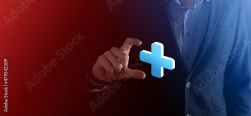 Businessman hold 3D plus icon, man hold in hand offer positive thing such as profit, benefits, development, CSR represented by plus sign.The hand shows the plus sign