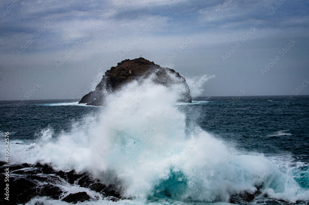 the sea hits the rocks and the islet hard