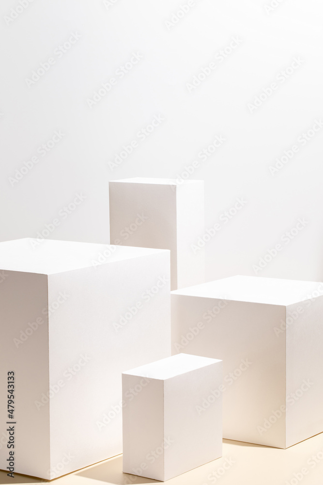 Abstract minimal nature scene - empty stage with four white rectangle podiums on beige background. Pedestal for cosmetic product and packaging mockups display presentation