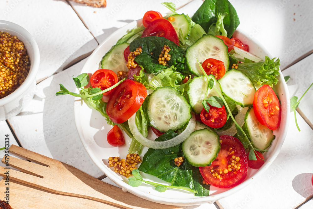 Vegetarian salad with cucumber, tomato and spinach in a plate Vegetarian salad with cucumber, tomato and spinach in a plate