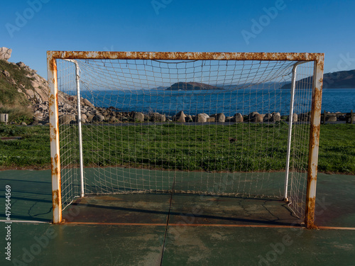 Bares, Galicia, Spain. Football goal with the Atlantic ocean and an island with a lighthouse in the background.