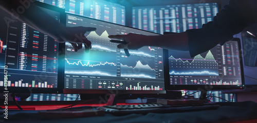 Two professional male economists looking at stock charts on monitors doing AltCoin analysis photo