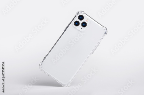 Silver iPhone 11 and 12 Pro max in clear silicone case falls down back view, phone case mockup isolated on gray background photo