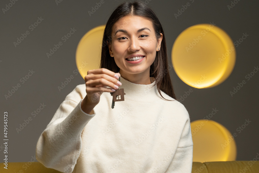 Portrait of a smiling Asian female tenant showing the keys to a new apartment, looking into the camera, a happy customer excited about buying a new house Portrait of a smiling Asian female tenant showing the keys to a new apartment, looking into the camera, a happy customer excited about buying a new house