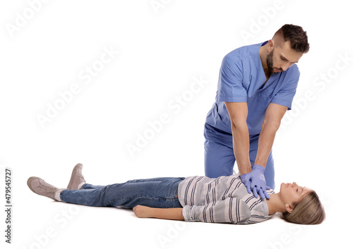 Doctor in uniform performing first aid on unconscious woman against white background