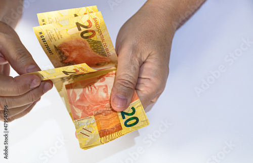 Holding 20 reais bills in his hands. Brazil money.