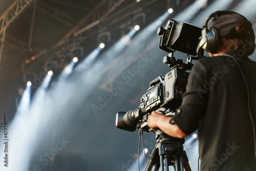 Professional camerawoman broadcasting live concert on camcorder. photo