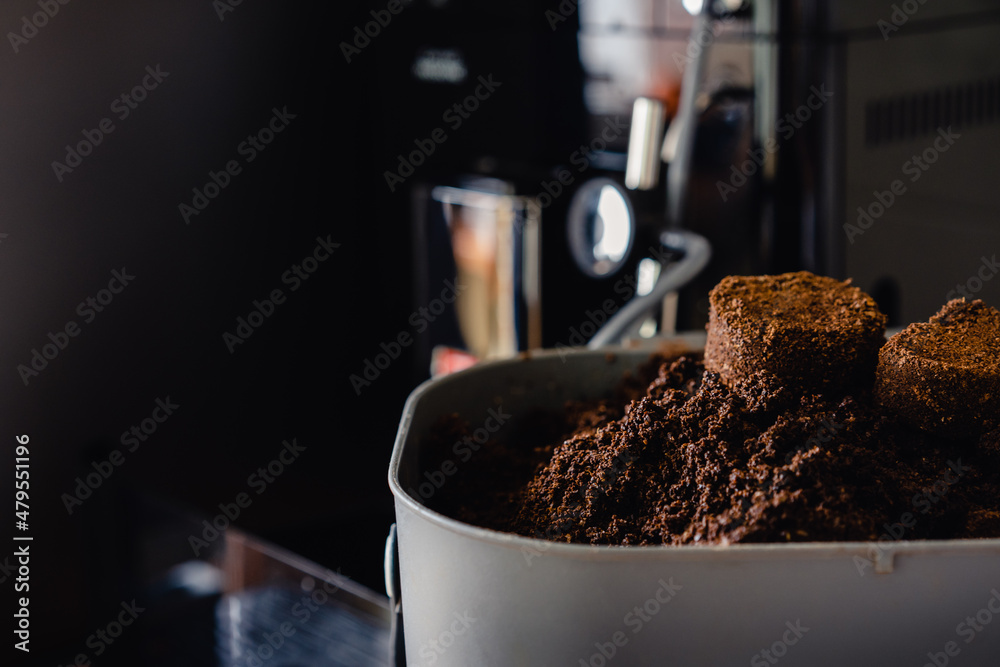 Used coffee grounds from espresso machine. Recycling compost container filled with used coffee