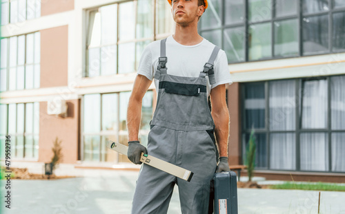 Ready for work. Young man in uniform at construction at daytime