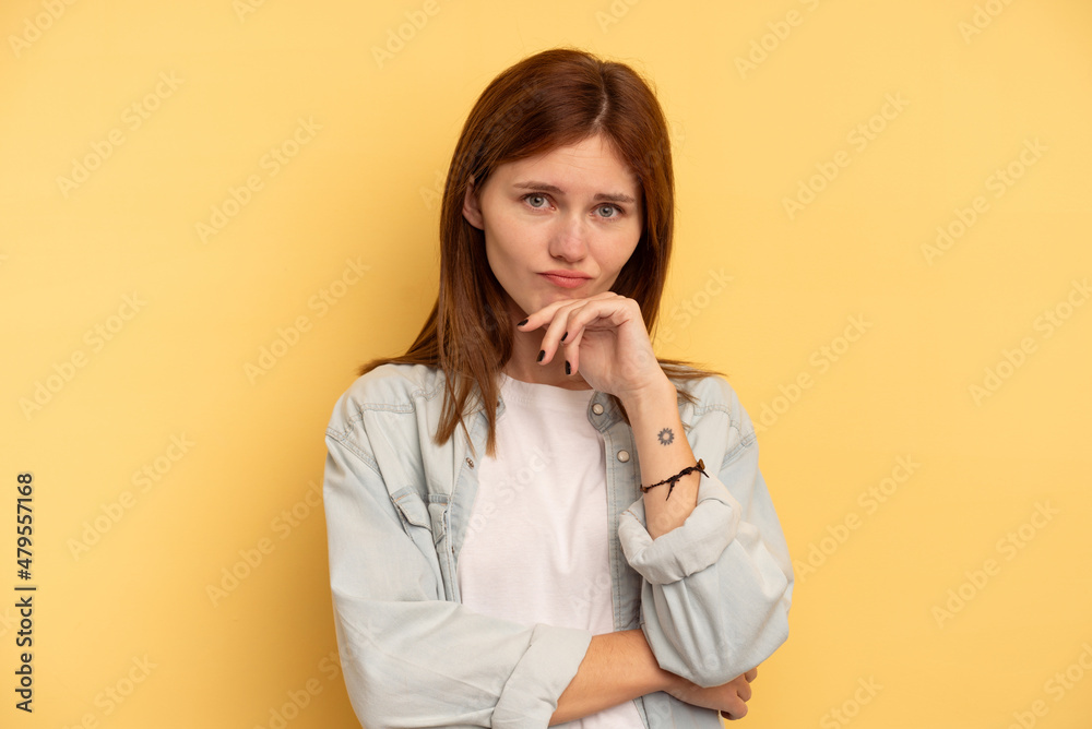 Young English woman isolated on yellow background thinking and looking up, being reflective, contemplating, having a fantasy. Young English woman isolated on yellow background thinking and looking up, being reflective, contemplating, having a fantasy.