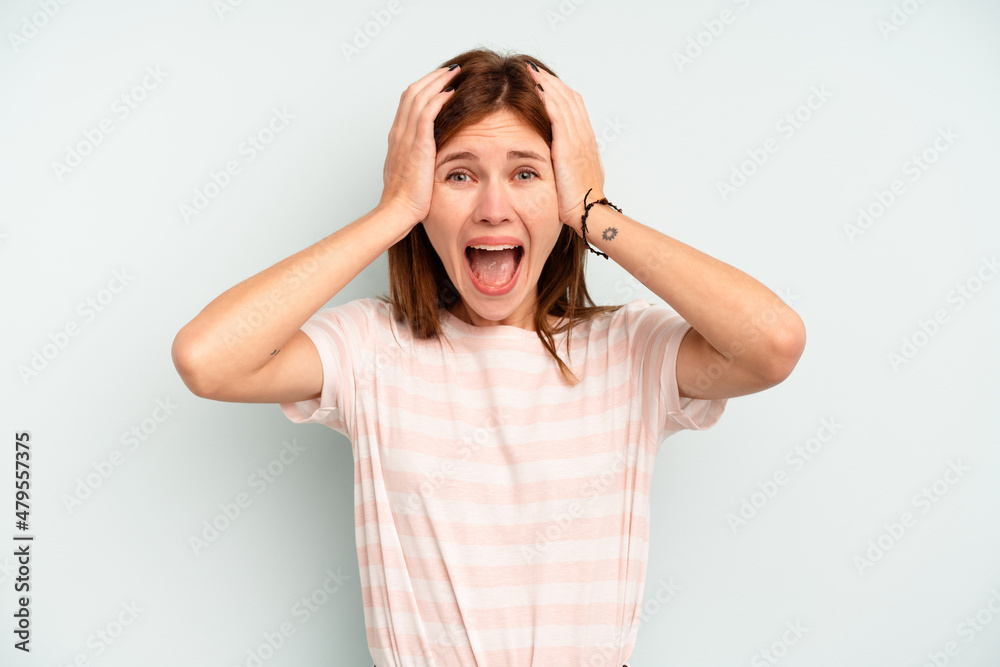 Young English woman isolated on blue background screaming, very excited, passionate, satisfied with something. Young English woman isolated on blue background screaming, very excited, passionate, satisfied with something.