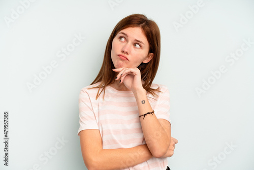Young English woman isolated on blue background thinking and looking up, being reflective, contemplating, having a fantasy.