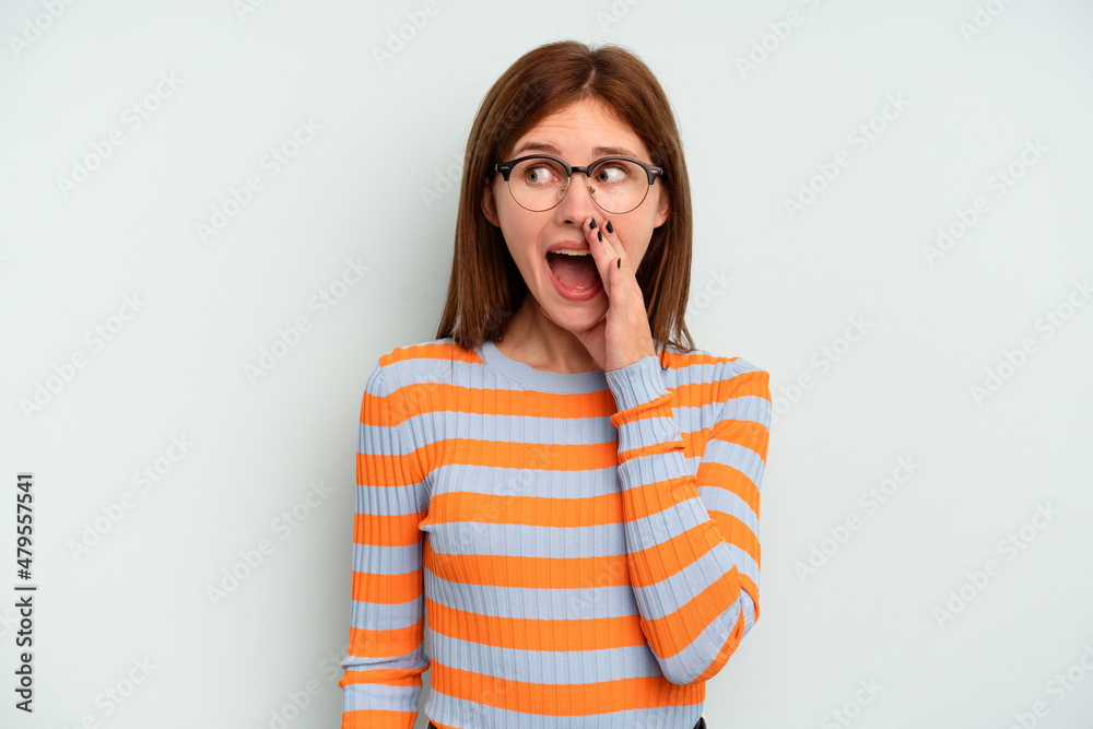 Young English woman isolated on blue background shouting excited to front.