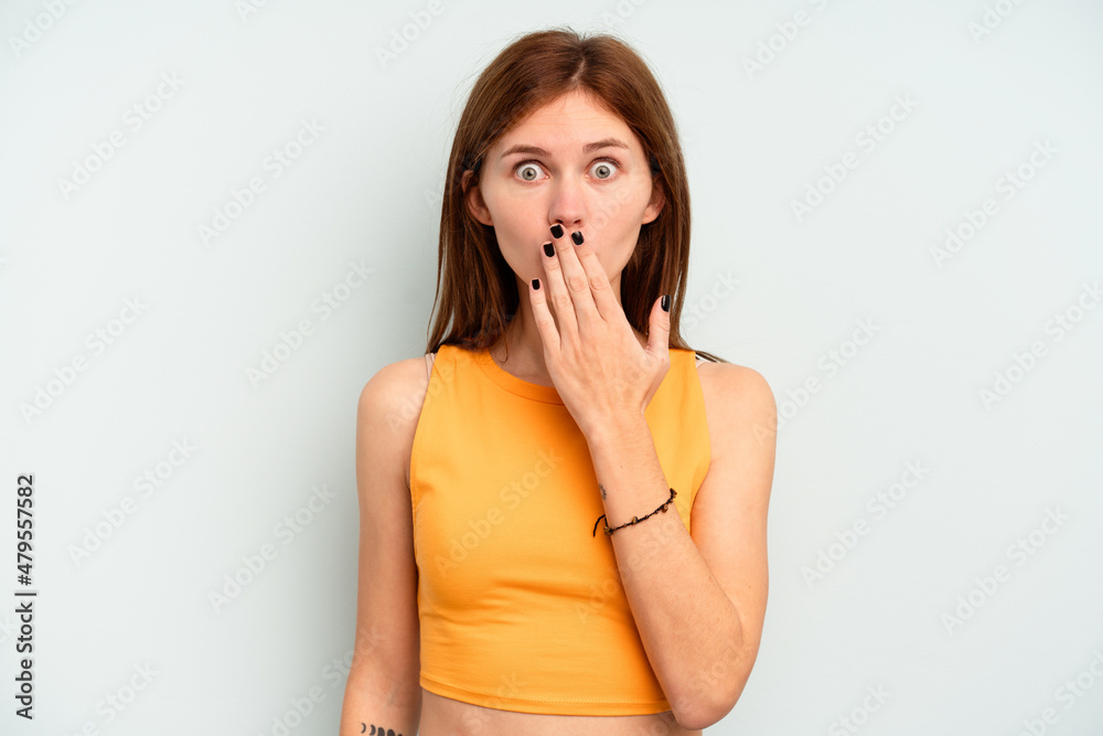 Young English woman isolated on blue background shocked, covering mouth with hands, anxious to discover something new. Young English woman isolated on blue background shocked, covering mouth with hands, anxious to discover something new.