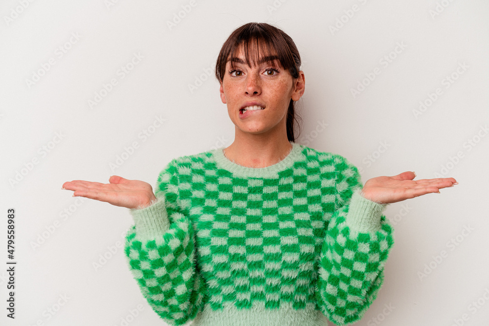 Young Argentinian woman isolated on white background confused and doubtful shrugging shoulders to hold a copy space.