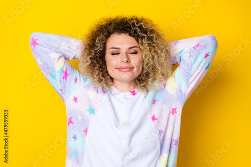 Portrait of attractive cheery dreamy wavy-haired girl in pajama drowsing relaxing isolated over vivid yellow color background
