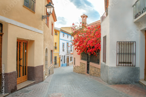 Fototapeta Naklejka Na Ścianę i Meble -  Small towns of Spain. A street in the picturesque town of Polop in the province of Alicante, not far from the famous resort of Benidorm. Travel and vacation concept. Blue sky in the background.
