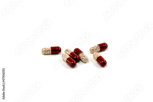 Composition with pills on the table. Heap of open medicines on a white paper background.