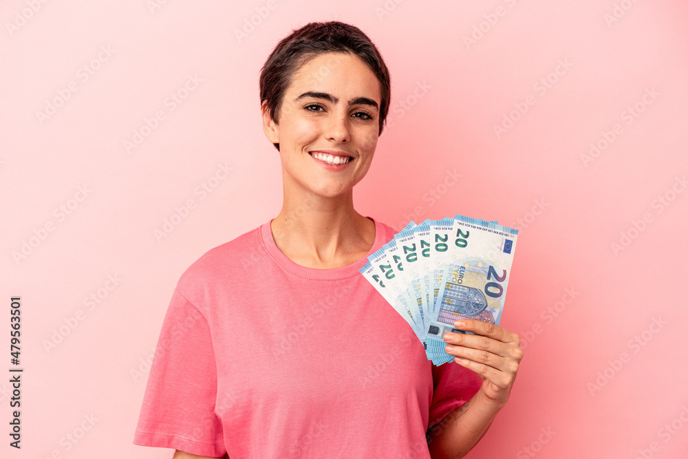 Young caucasian woman holding banknotes isolated on pink background happy, smiling and cheerful. Young caucasian woman holding banknotes isolated on pink background happy, smiling and cheerful.
