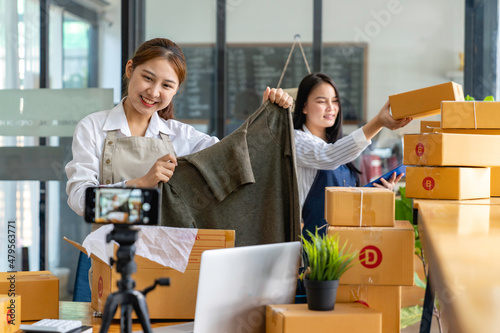 Startup small business SME. Beautiful asian entrepreneur using camera live streaming online chat with her customer. Successful SME business online concept..