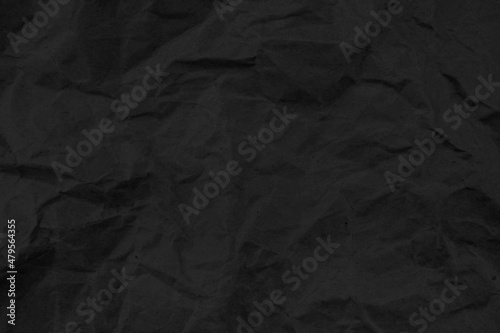 Recycled black creased paper background or cardboard surface from a paper box for packing. crumpled paper concept