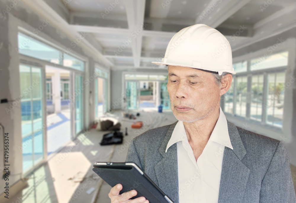 senior Asian construction architect inspecting the workplace.