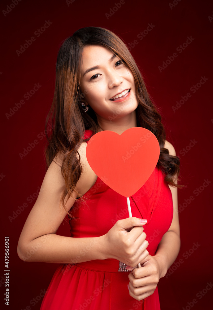 Portrait pretty woman holding red heart card celebrating happy birthday party on red background. Valentine's Day Portrait pretty woman holding red heart card celebrating happy birthday party on red background. Valentine's Day