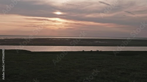 Faraway view of people silhouettes standing and walking near boats that are near the river on shore. Research in Yamal Peninsula. photo