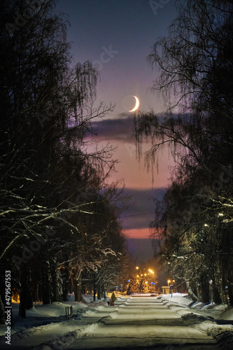 half moon at the end of a city walley in winter sunset