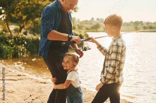 Father with son and daughter on fishing together outdoors at summertime #479567701