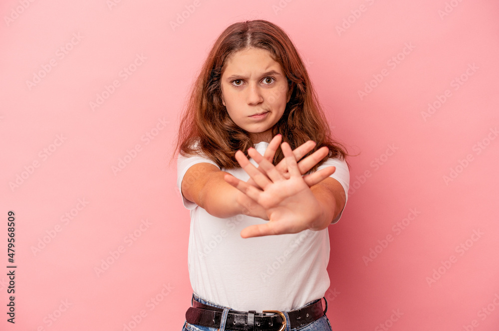 Little caucasian girl isolated on pink background standing with outstretched hand showing stop sign, preventing you. Little caucasian girl isolated on pink background standing with outstretched hand showing stop sign, preventing you.