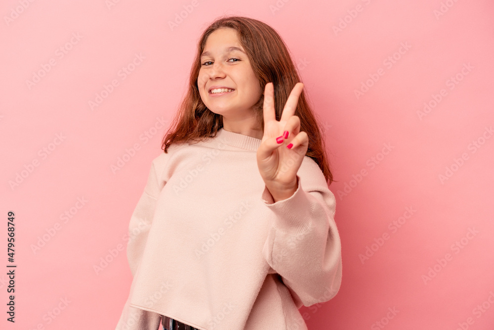 Little caucasian girl isolated on pink background joyful and carefree showing a peace symbol with fingers. Little caucasian girl isolated on pink background joyful and carefree showing a peace symbol with fingers.